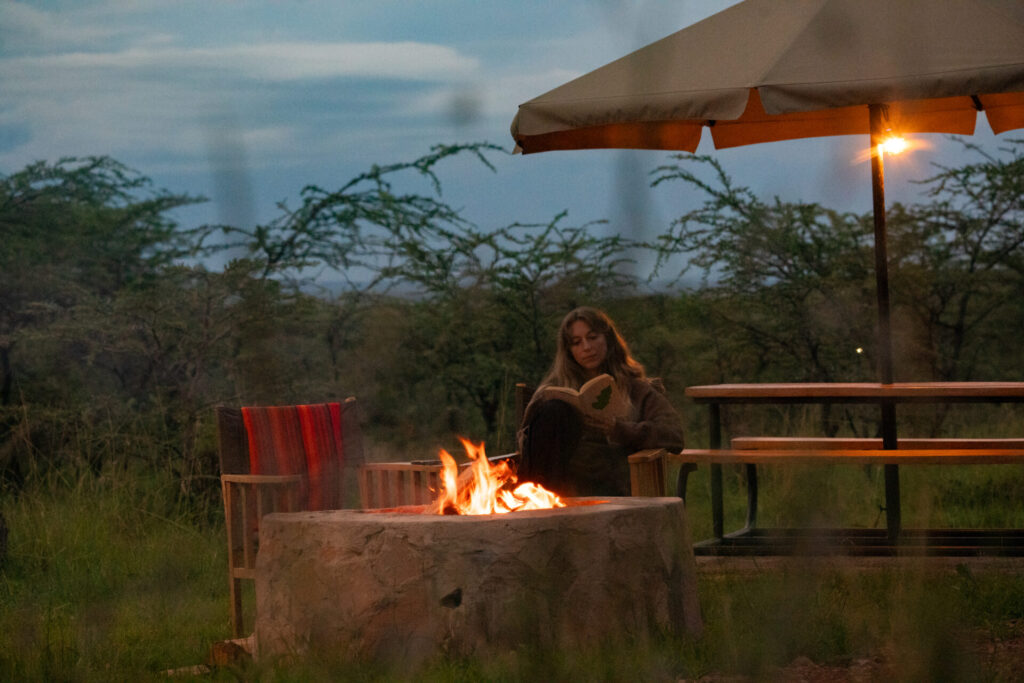 Guest enjoying an evening campfire outside the lodge.
